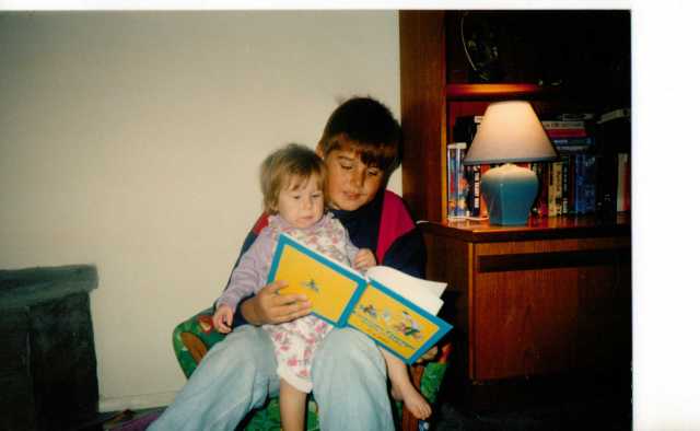 Eldest Son reading to Aspie D - Another favourite, Curious George.  Extra lighting needed! 1993. (c) Sherri Matthews 2014